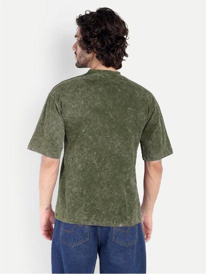 Man wearing a green t-shirt and blue jeans against a white background