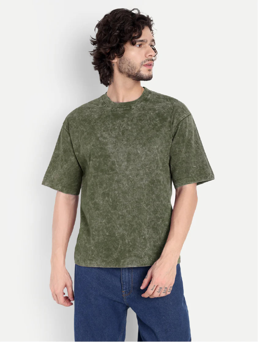 Man wearing a green t-shirt and blue jeans against a white background