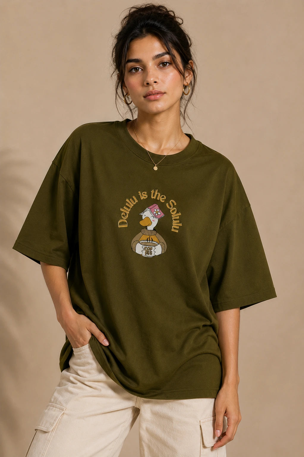 Female model wearing Delulu Is The Solulu olive green unisex graphic streetwear T-shirt made from premium 240 GSM cotton
