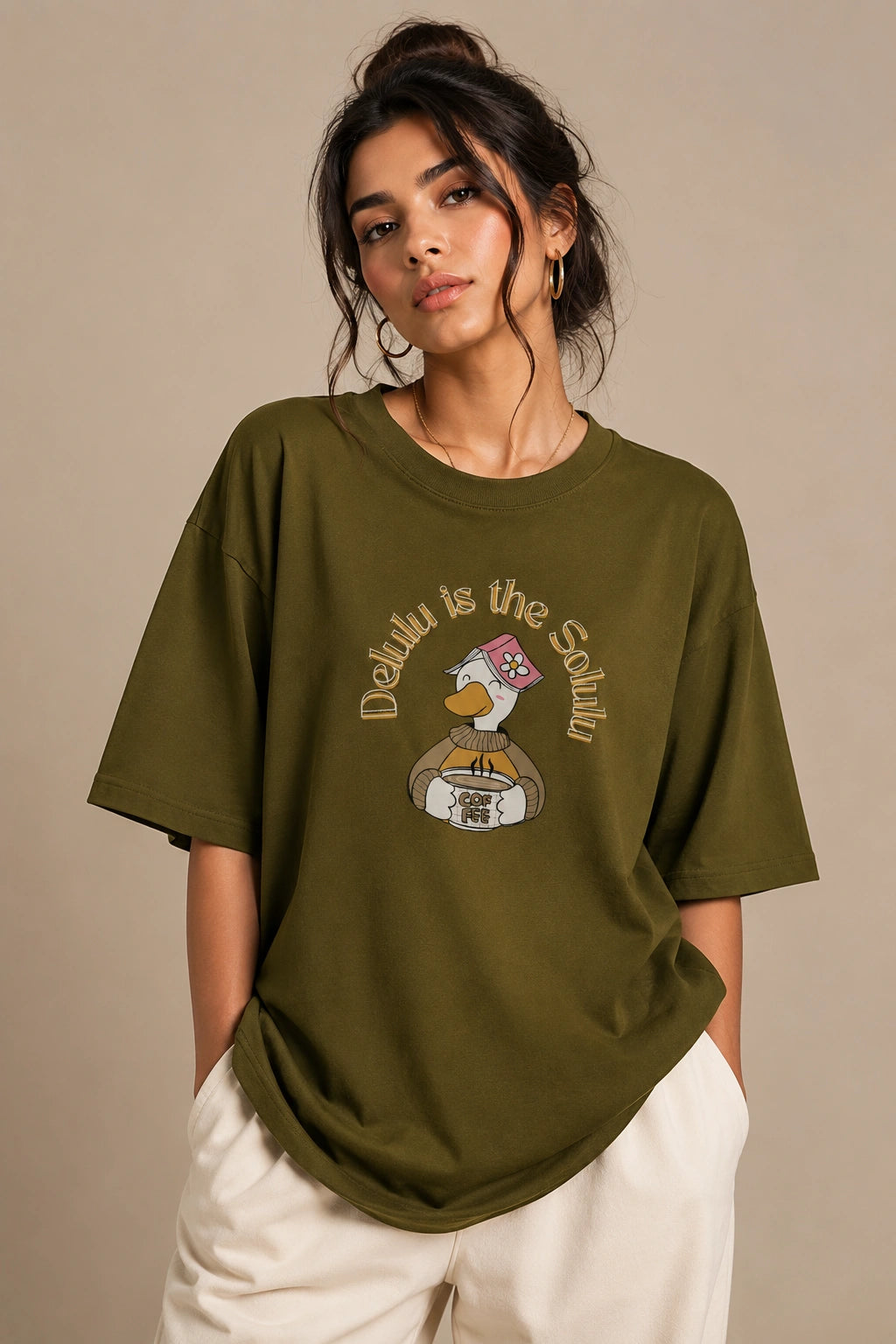 Female model wearing Delulu Is The Solulu olive green unisex graphic streetwear T-shirt made from premium 240 GSM cotton