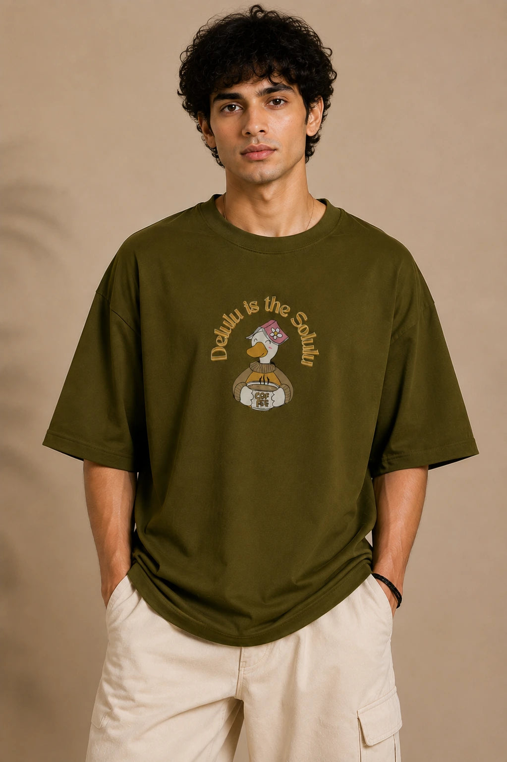 Male model wearing Delulu Is The Solulu olive green unisex graphic streetwear T-shirt made from premium 240 GSM cotton