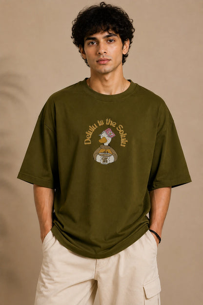 Male model wearing Delulu Is The Solulu olive green unisex graphic streetwear T-shirt made from premium 240 GSM cotton