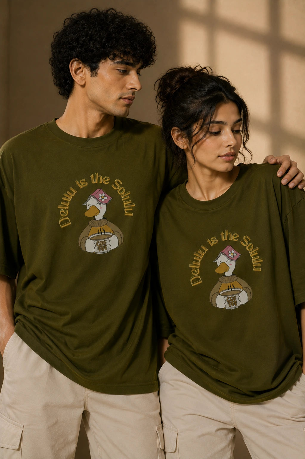 Male and female model wearing Delulu Is The Solulu olive green unisex graphic streetwear T-shirt made from premium 240 GSM cotton