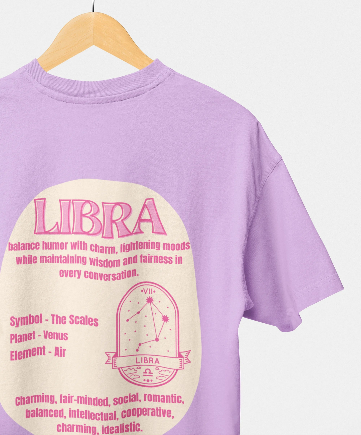 Purple t-shirt with Libra zodiac design on a hanger against a white background